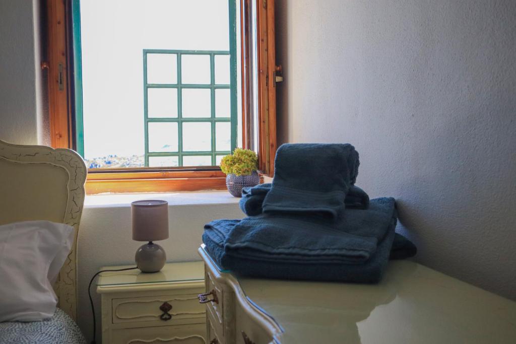 una silla azul sentada en una mesa junto a una ventana en Primor Serra AL, en Covilhã