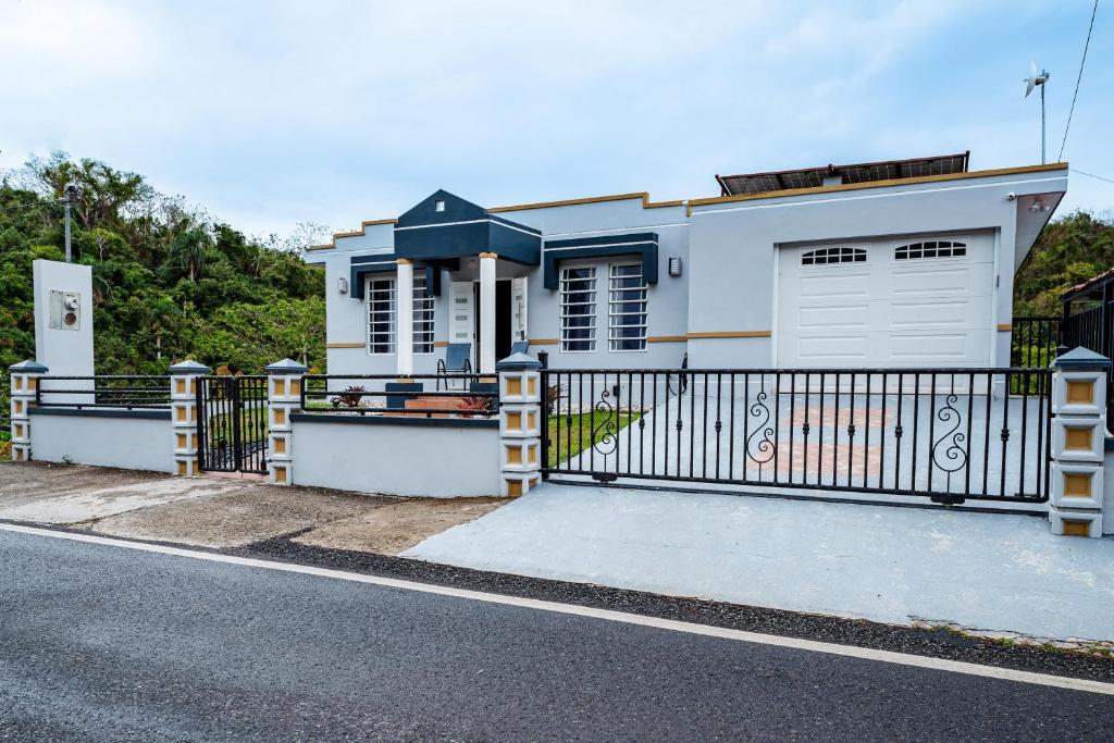 a white house with a gate and a fence at Green Studio 1 - just 7 min drive to the beach in Rincon