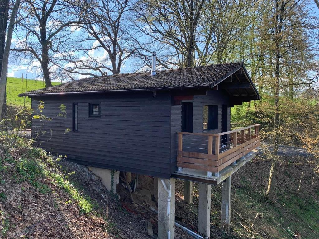 a small house with a deck in the woods at Gîtes Douillets : Chalet sur Pilotis in Houyet