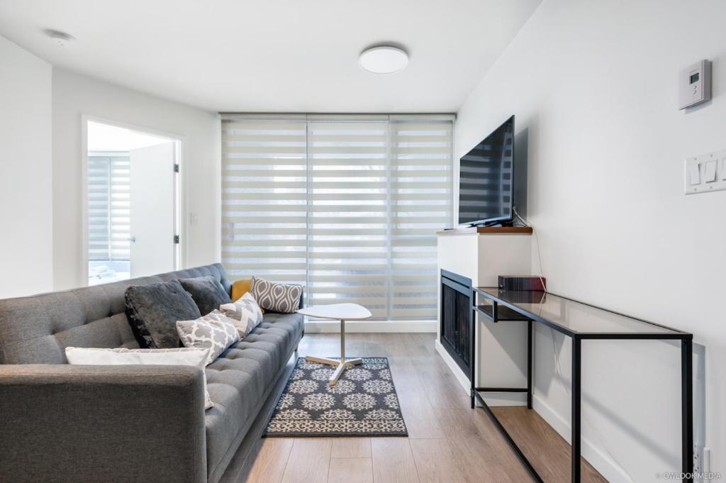 a living room with a couch and a television at Modern DT Vancouver 1BD Condo in Vancouver