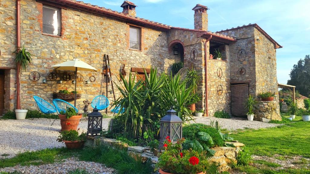 una casa in pietra con delle piante davanti di Agriturismo Podere Le Palaie a Monterotondo