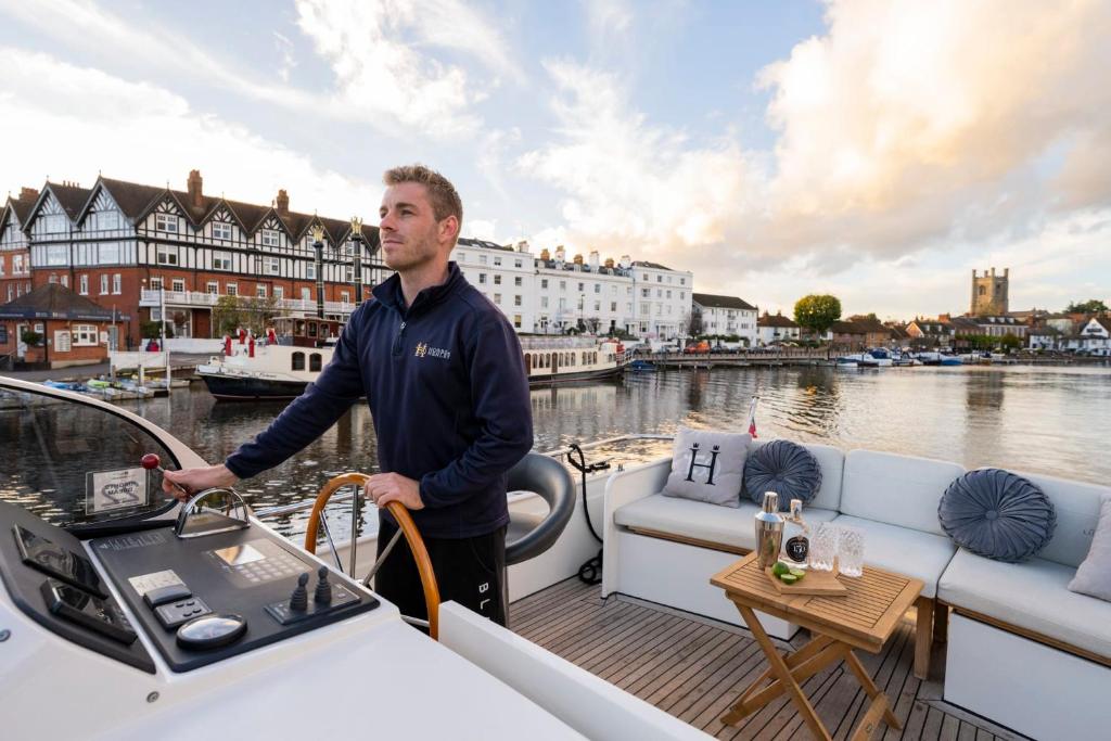 un hombre parado en la cubierta de un barco en Knightsdream - Unforgettable 2 Night Stay en Henley on Thames