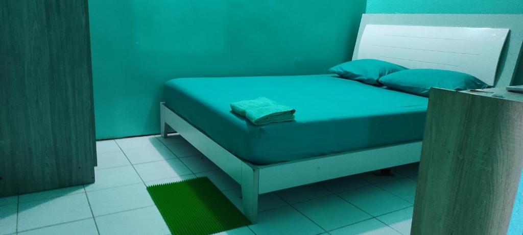faTuur Inn في مدينة ماليه: سرير صغير مع ملايات زرقاء ومخدات زرقاء