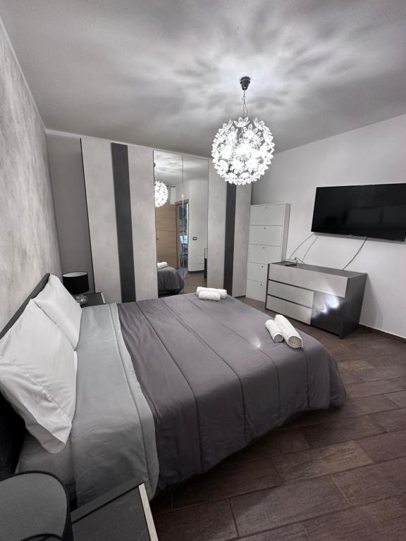 Un dormitorio con una cama grande y una lámpara de araña. en Rena Bianca Apartment, en Porto Torres