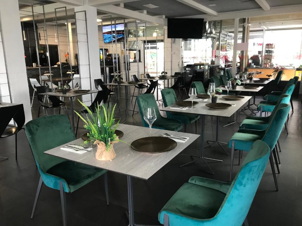 una fila de mesas y sillas con sillas verdes en Hotel Chips Ferrol, en Narón