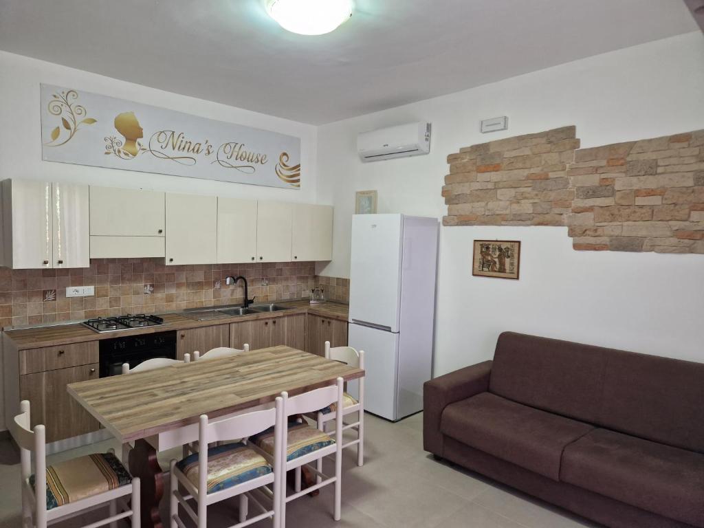 a kitchen and living room with a table and a couch at Nina's house 1 a 300 metri dal mare in Santa Caterina Dello Ionio Marina