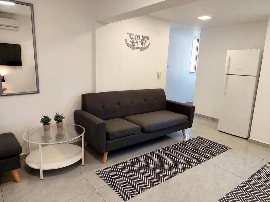 uma sala de estar com um sofá e uma mesa de vidro em Cute and cosy 2 rooms Apartment em Ashdod