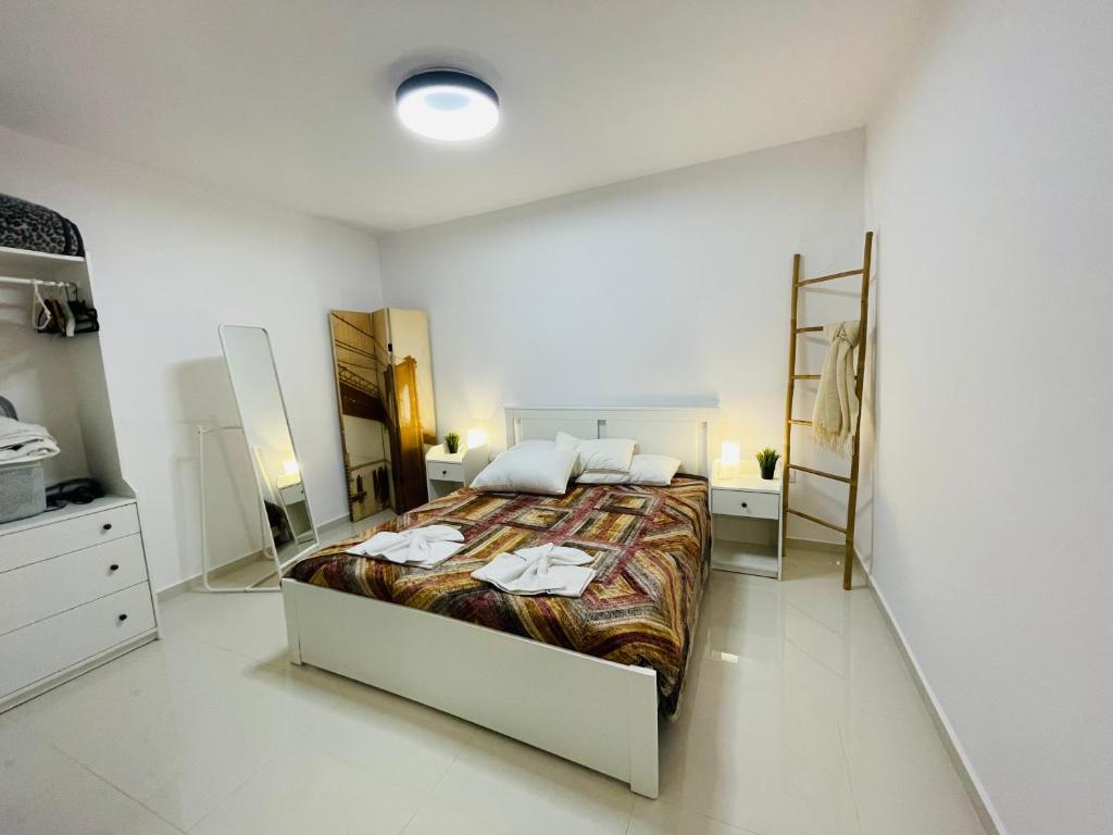 um quarto com uma cama grande num quarto branco em Haris white apartment em Roussospítion