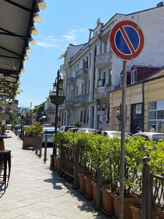 a street with plants and a sign on a pole at Melson in Batumi