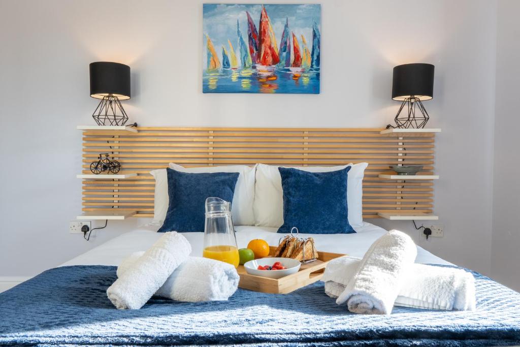 ein Schlafzimmer mit einem Tablett mit Essen auf dem Bett in der Unterkunft Homely Two Bedroom Apartment in Milton Keynes - Free Parking, WiFi, Sky TV & Netflix in Milton Keynes