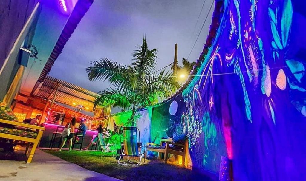 a wall with graffiti on it with a palm tree at Santo hostel in Paraty