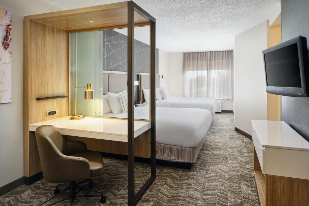 a hotel room with a bed and a desk and a tv at SpringHill Suites Edgewood Aberdeen in Bel Air