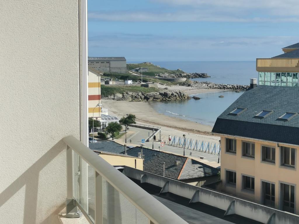 uma vista para a praia a partir da varanda de um edifício em Burela-Ensenada-playa em Burela de Cabo