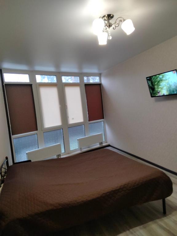 - une chambre avec un grand lit et quelques fenêtres dans l'établissement Квартира в ЖК Атриум, à Irpin