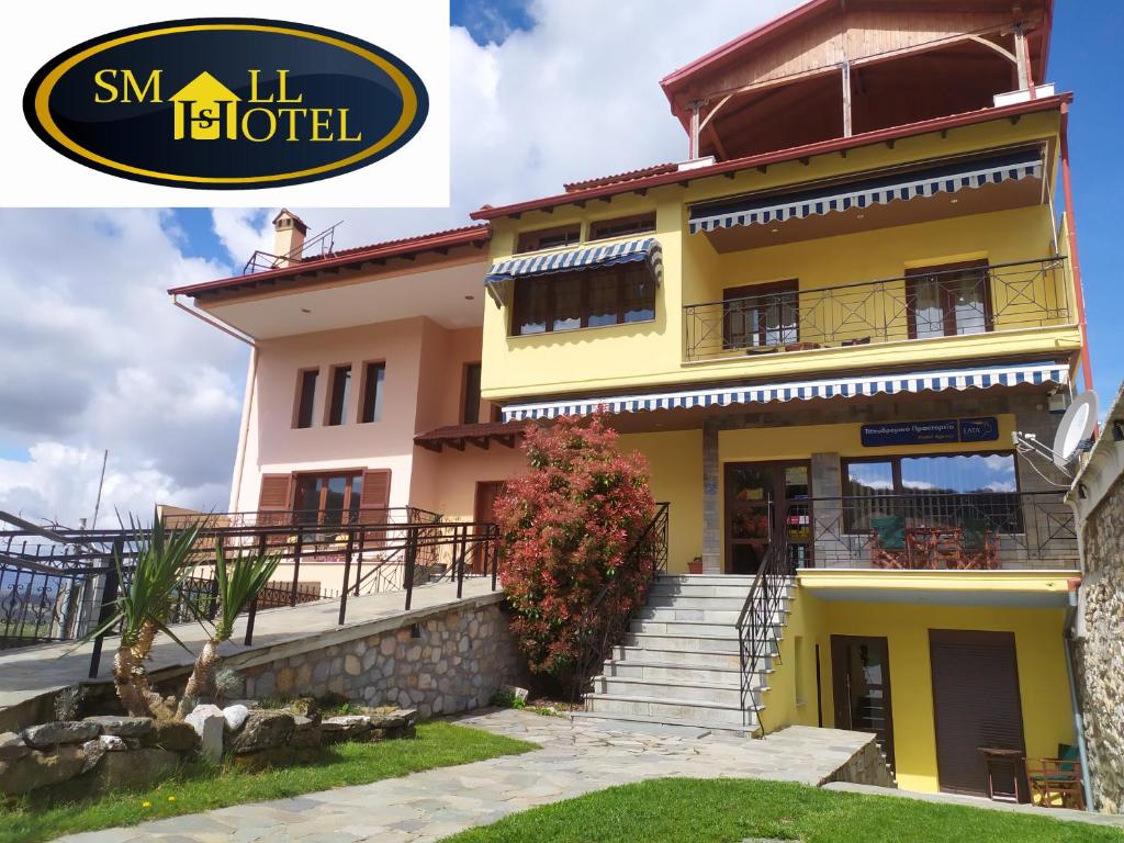 a large yellow house with stairs in front of it at SmallHotel - Vevi in Vévi