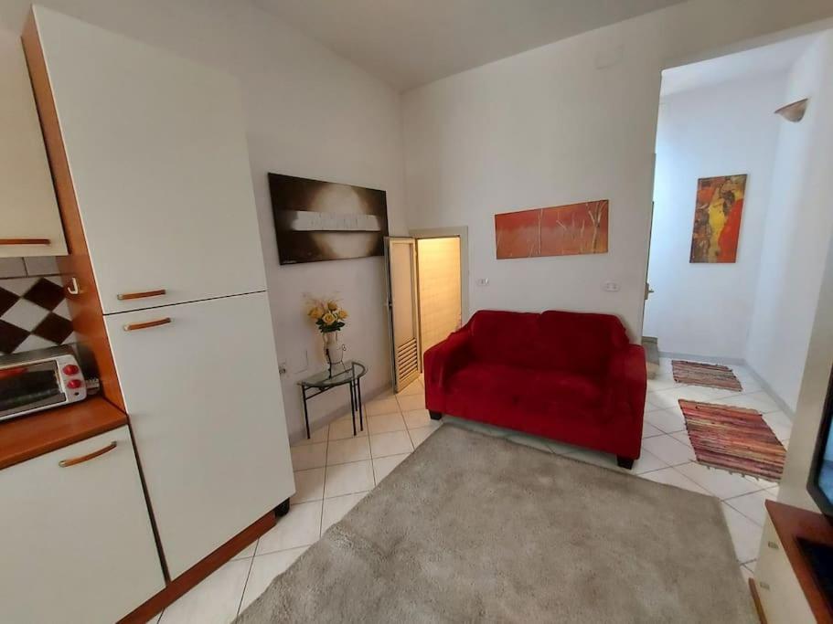 a living room with a red couch and a refrigerator at Delizioso appartamento Frosinone centro storico in Frosinone