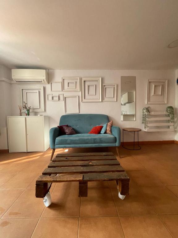 Sala de estar con sofá azul y mesa de centro en Apartamento Valencia, en Catarroja
