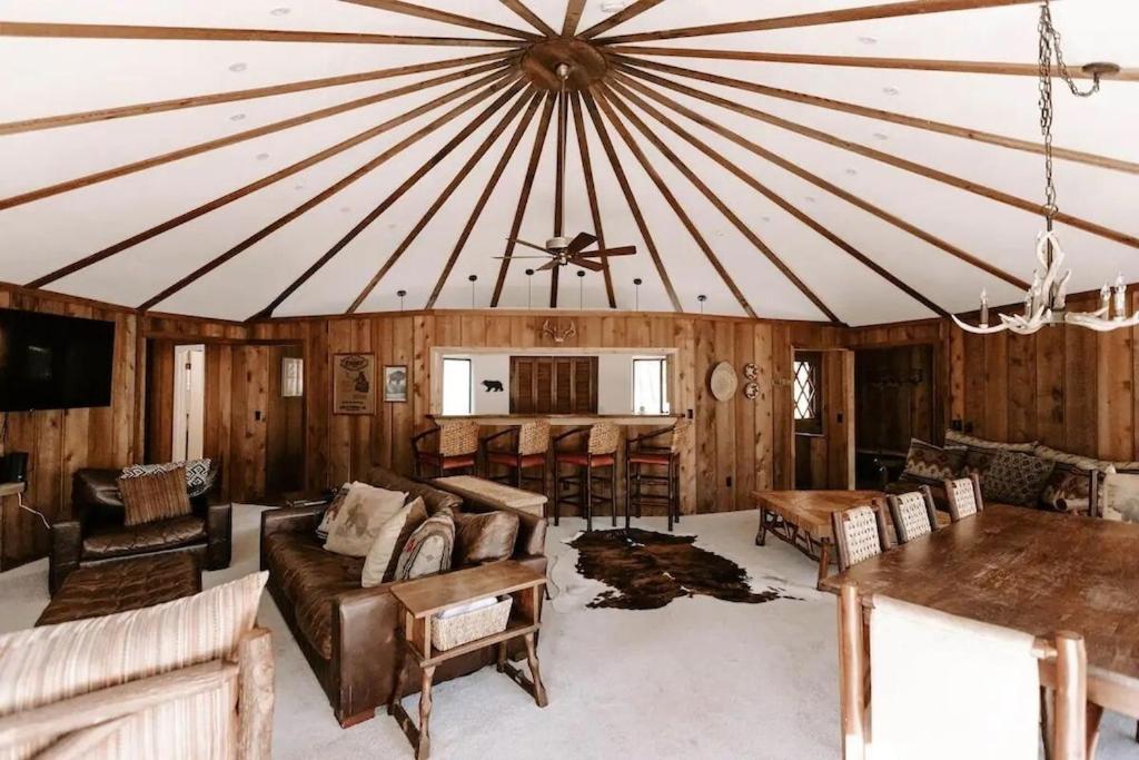 a living room with a large roof with furniture and a table at Cabin with Treehouse Views, 3 King Beds, 4 Bunks, and Large Hot Tub! in Gatlinburg
