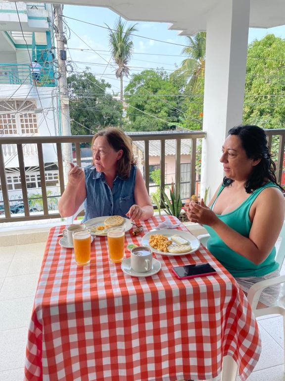 トルにあるCasa Inés Tolúの二人の女がテーブルに座って食べ物を食べている