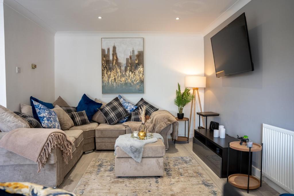 a living room with a couch and a tv at Four Bedroom, Four Bathroom Home in Milton Keynes by HP Accommodation in Milton Keynes