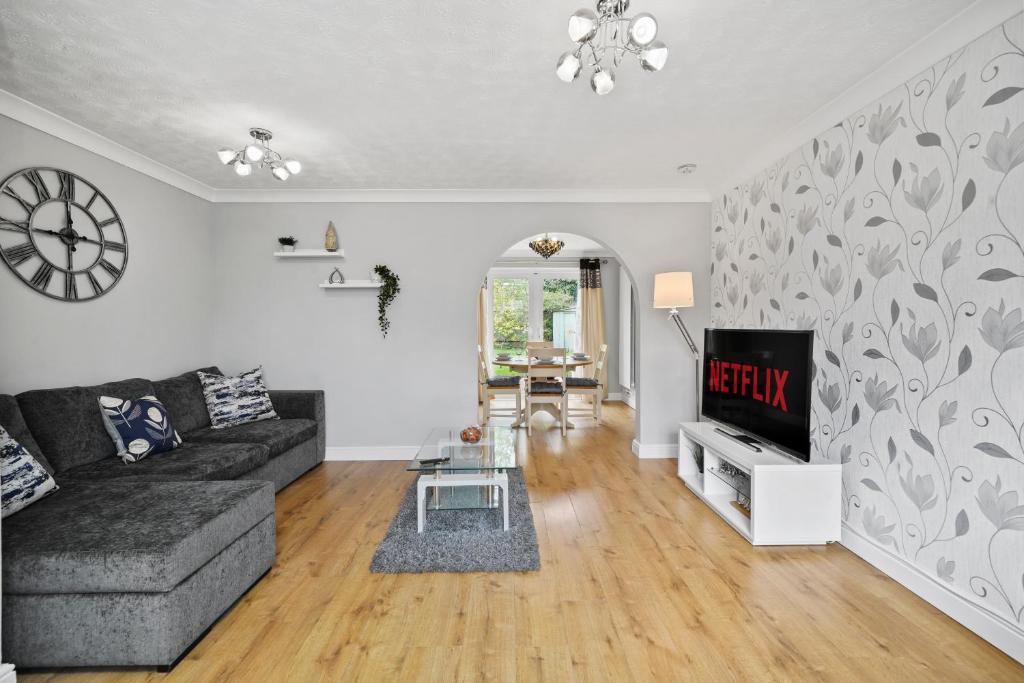 ein Wohnzimmer mit einem Sofa und einem TV in der Unterkunft Three Bedroom Home Near Central Milton Keynes by HP Accommodation with Free Parking, WiFi & Sky TV in Milton Keynes