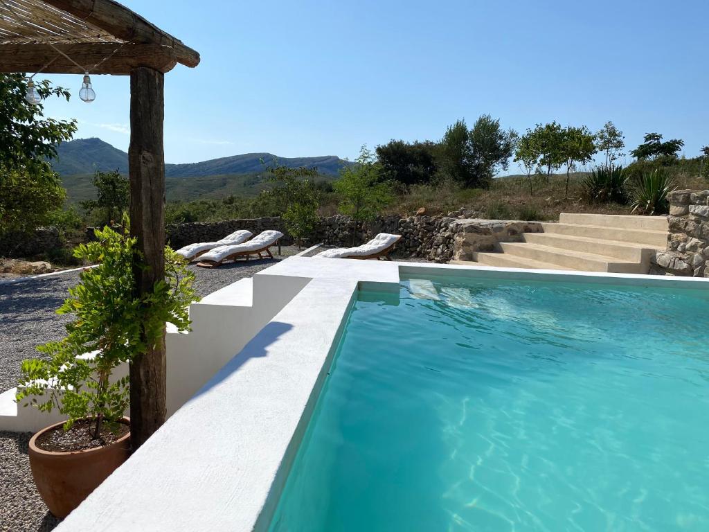 una piscina en una villa con montañas en el fondo en Masía La Costereta, en Catí