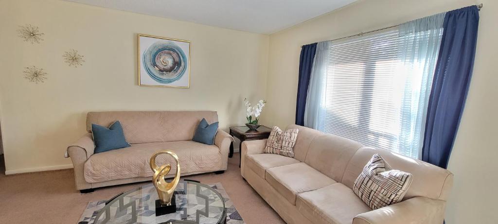 a living room with a couch and a glass table at Prime Location for UF Visitors 2BR Condo with Pool and Fast Wi-Fi in Gainesville
