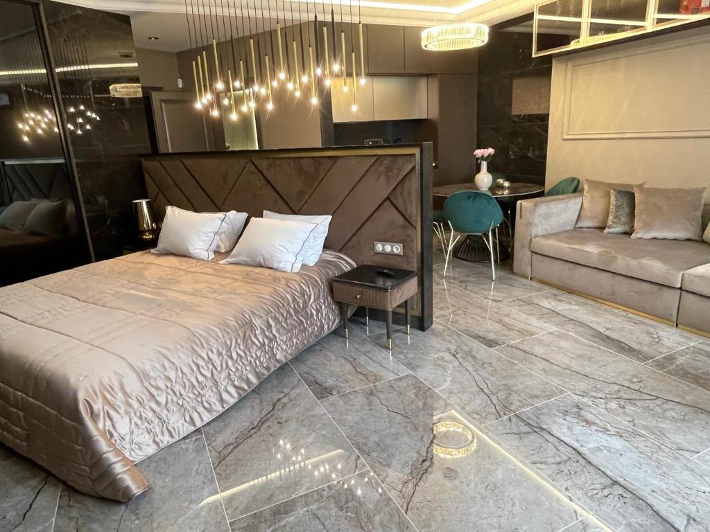 a bedroom with a large bed and a couch at Apart Elena Arcadia Sea View in Odesa