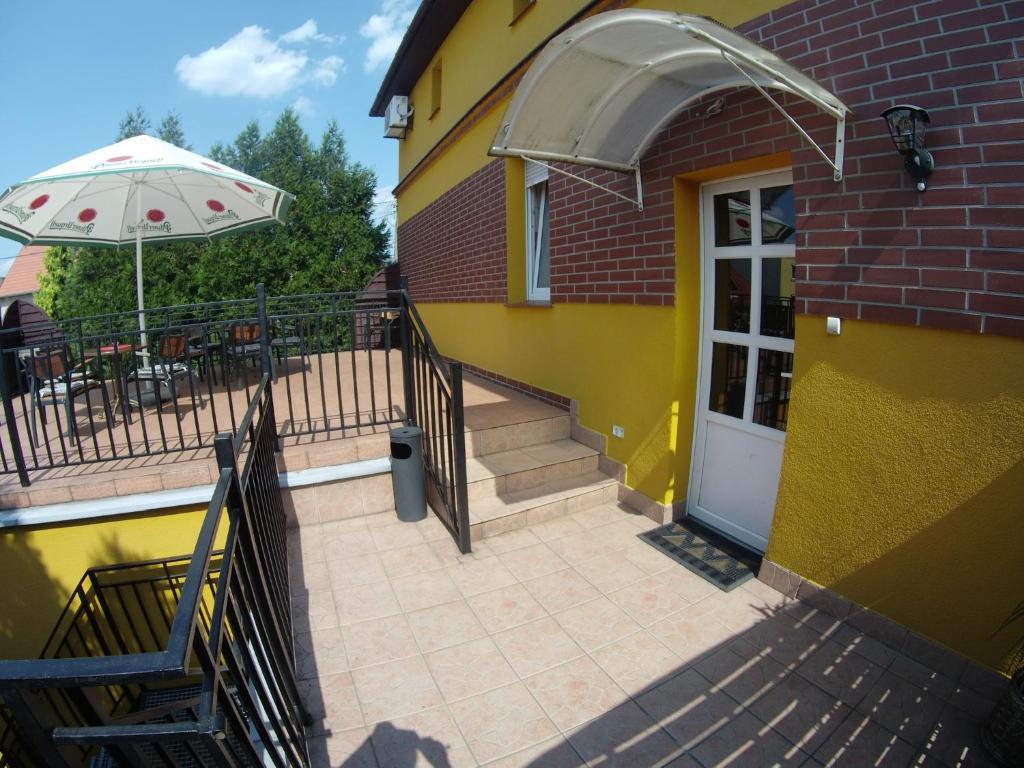 a yellow building with a white door and an umbrella at Pasja Noclegi B&B in Wołów