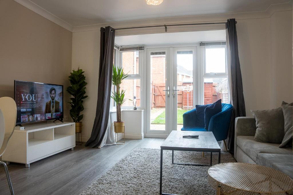 a living room with a couch and a tv at Homely 3 Bedroom House with Private Parking in Milton Keynes by HP Accommodation in Milton Keynes