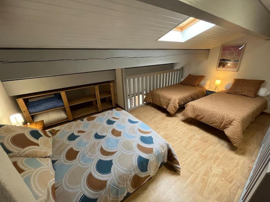 Un dormitorio con dos camas en una habitación. en Maison 400m plage, en Mimizan