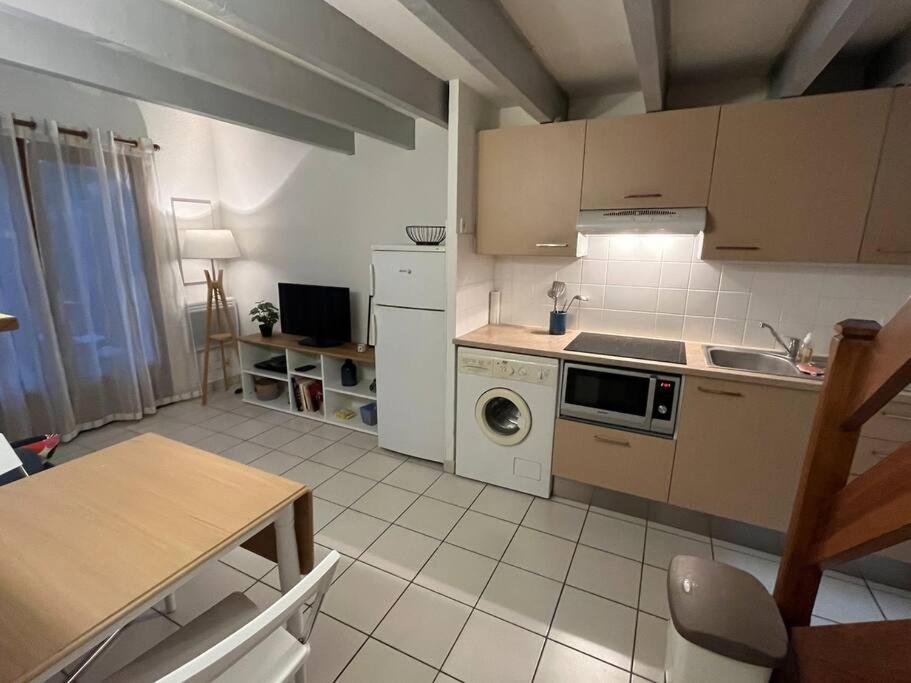 una cocina con fregadero y estufa horno superior en Maison 400m plage, en Mimizan