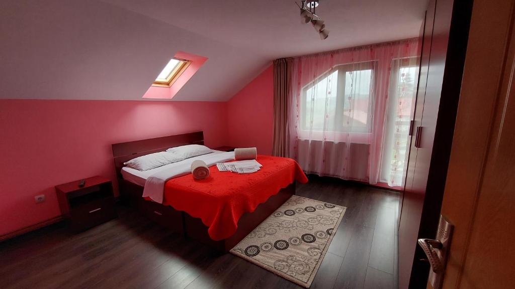 a red bedroom with a bed with a red blanket at Vila Coman in Întorsura Buzăului