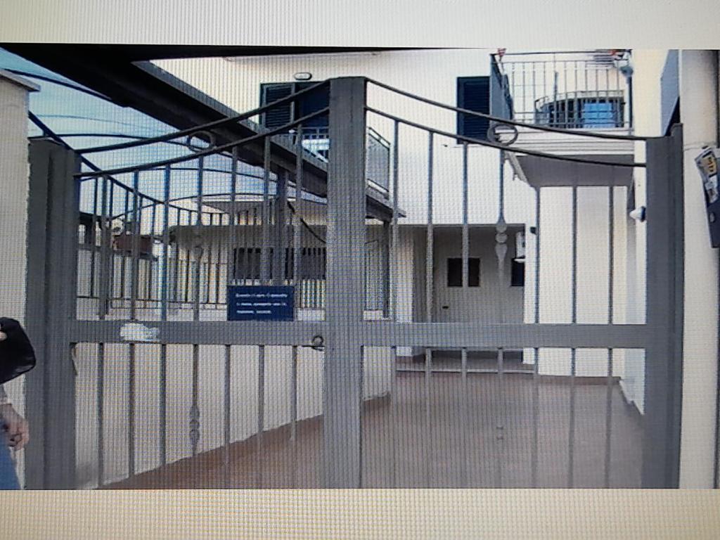 a gate in front of a building with a balcony at Il Girasole in Caserta