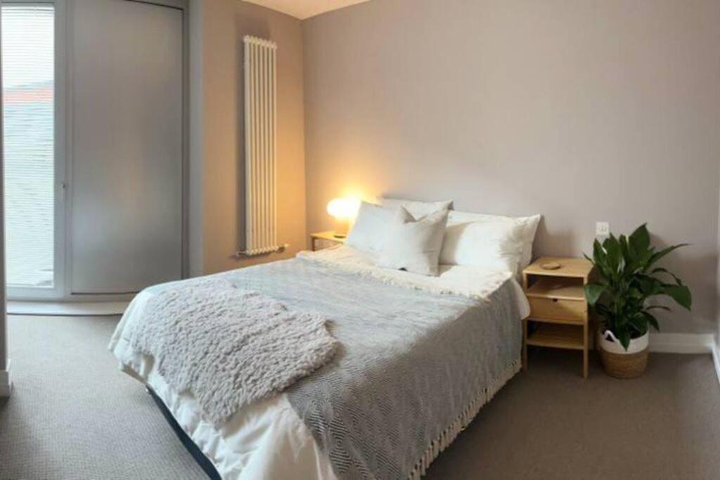 1 dormitorio con cama y mesita de noche con planta en City Apartment with Terrace, en Leicester