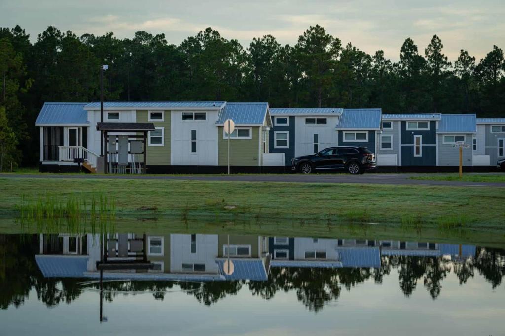 eine Reihe von Mobilheimen neben einem Wasserkörper in der Unterkunft Gulf Shores RV Resort in Gulf Shores