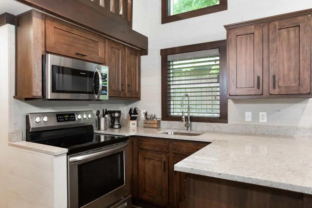 uma cozinha com armários de madeira e um forno com placa de fogão em Gulf Shores RV Resort em Gulf Shores