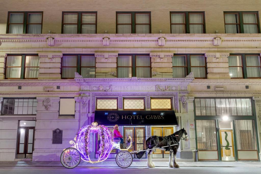 Hotel Gibbs Downtown Riverwalk في سان انطونيو: عربة تجرها الخيول امام المبنى