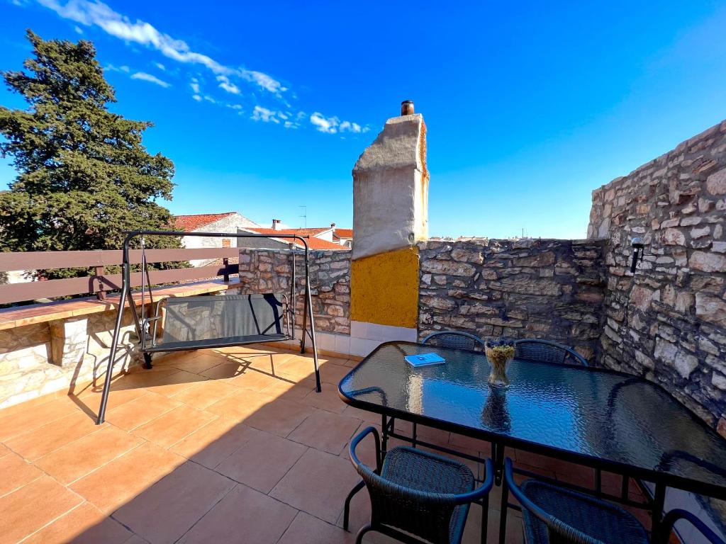 a patio with a table and chairs on a stone wall at Apartment Moris in Vodnjan