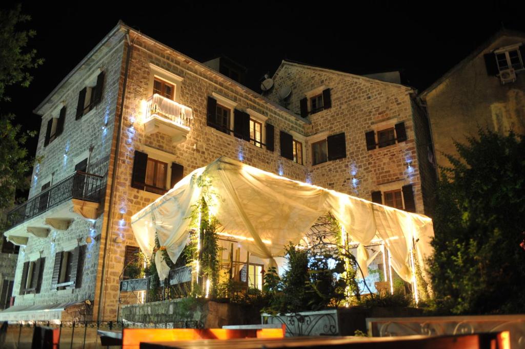 um edifício com uma tenda em frente à noite em Hotel Villa Duomo em Kotor