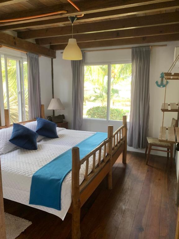 a bedroom with a large bed with blue pillows at Casa, Cabo Tortugas, Monterrico in Monterrico