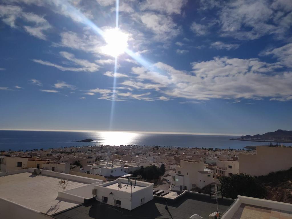 una vista de una ciudad con el sol en el cielo en Luz de Mar., en Carboneras