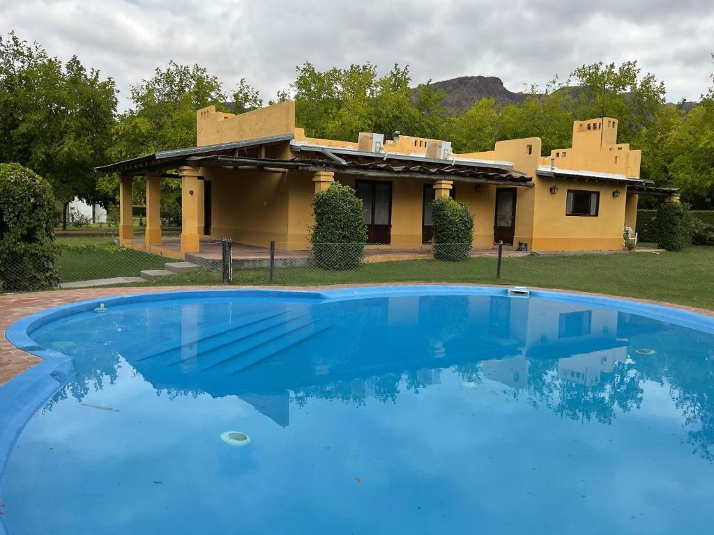 a large blue swimming pool in front of a house at Chalet Ailinco in Valle Grande