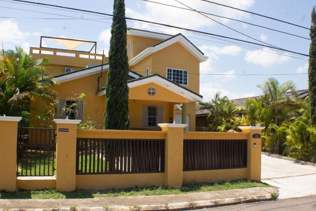 a yellow house with a fence at The Vista Inn in Falmouth