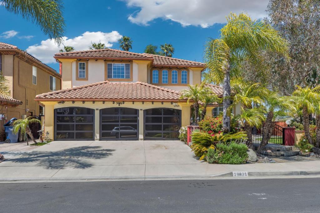 a house with a garage and palm trees at A Stunning Beach villa Walking to Huntington Beach in Huntington Beach