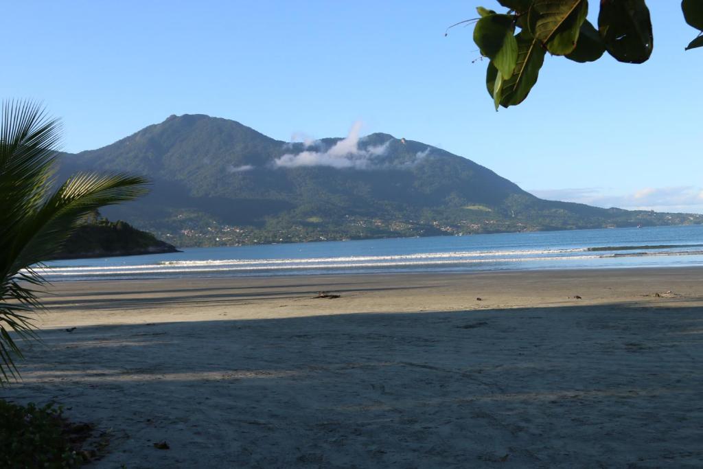 una vista di una spiaggia con una montagna sullo sfondo di Pé na Areia - Casa para temporada a São Sebastião