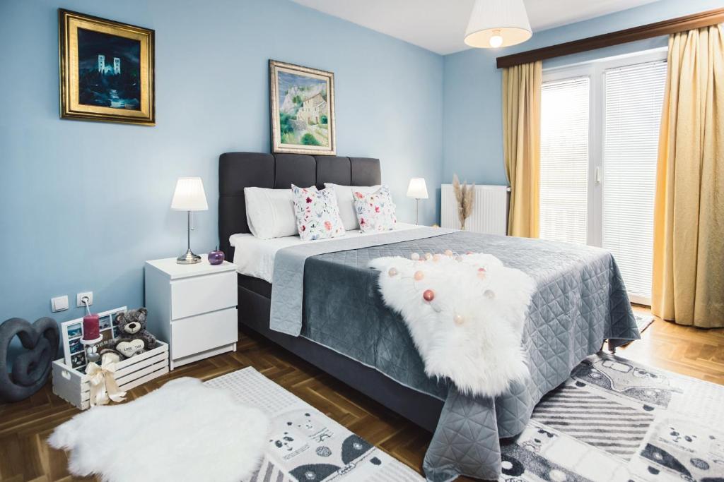 um quarto com uma cama grande e paredes azuis em Luxury Apartment Leonarda on the river Vrljika em Imotski