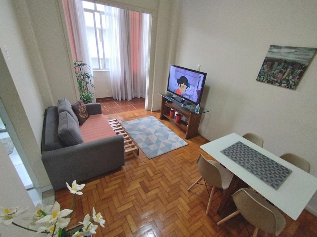 een woonkamer met een bank en een televisie bij Boemia Carioca Lapa in Rio de Janeiro