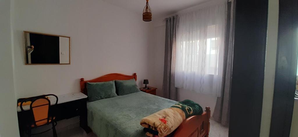 ein kleines Schlafzimmer mit einem Bett und einem Fenster in der Unterkunft APPARTEMENT AL HOCEIMA prés de PLAGE CALABONITA in Al Hoceïma