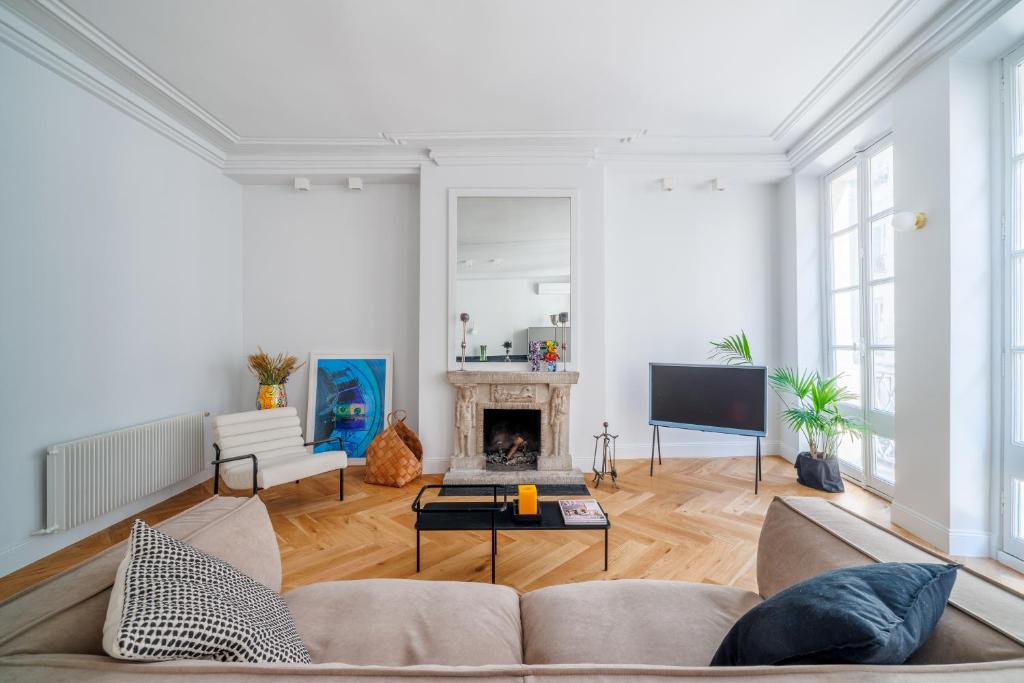 a living room with a couch and a fireplace at Luxury Living à Montorgueil in Paris